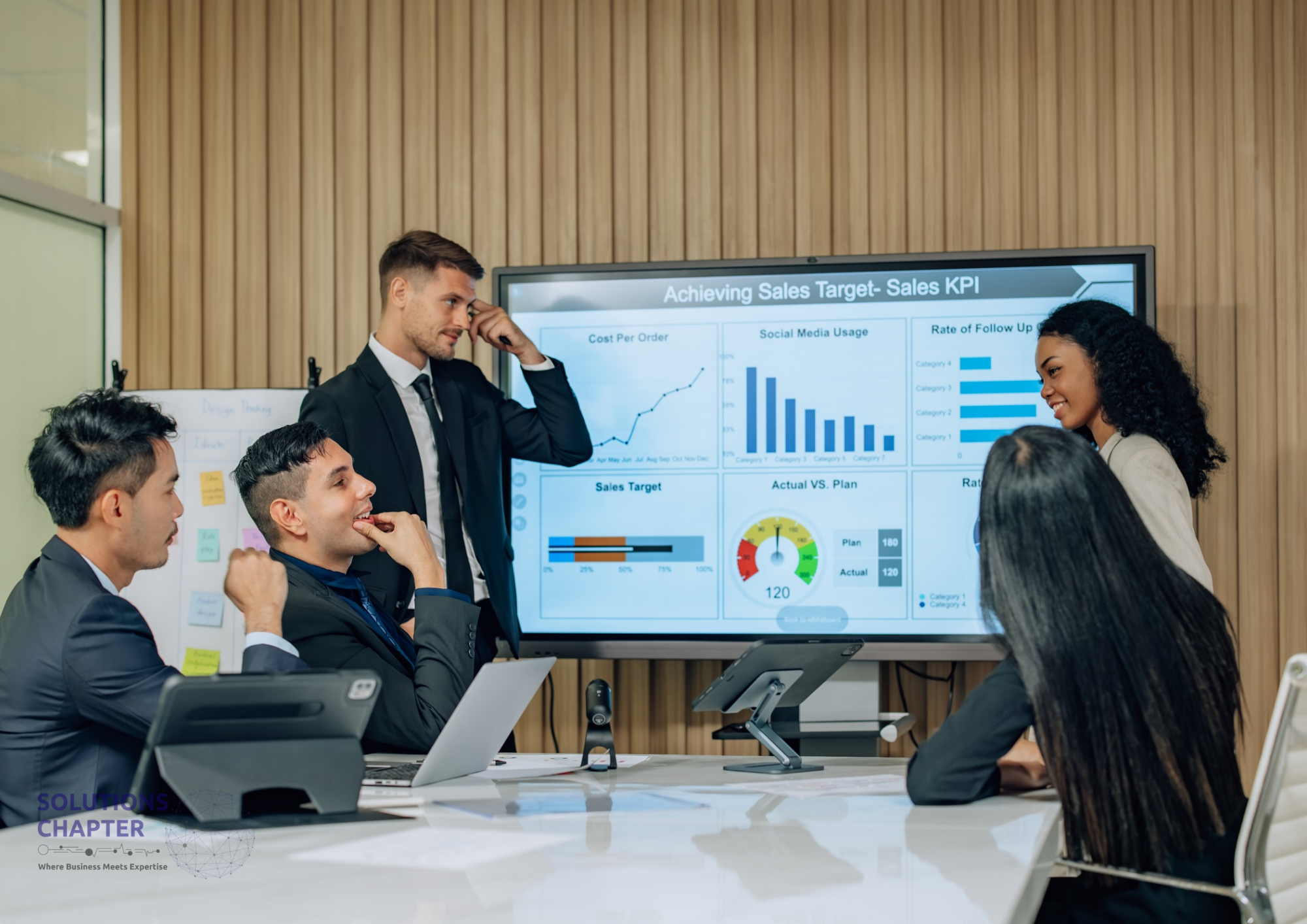 A diverse team of five business professionals gathers in a modern office to review a 